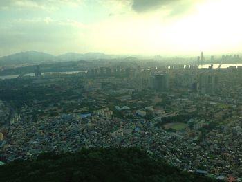 View of cityscape against cloudy sky