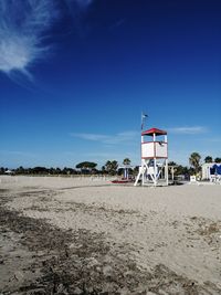 Hut on beach against blue sky