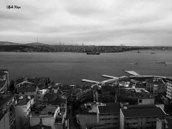 High angle view of town by sea against sky