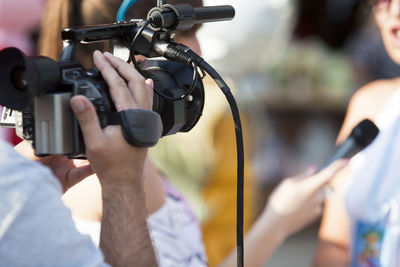 Midsection of man photographing at camera