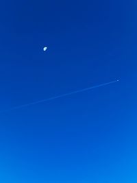 Low angle view of vapor trail in blue sky