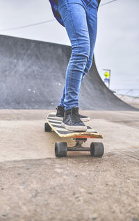 Low section of man skateboarding on floor