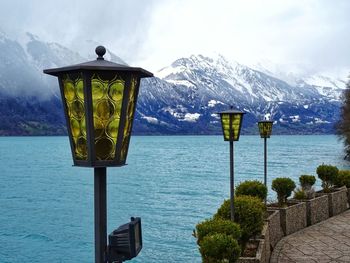 Street light by sea against sky