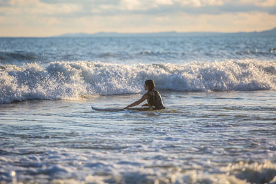 Man surfing in sea against sky