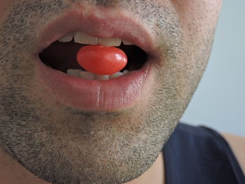 Midsection of man eating candy