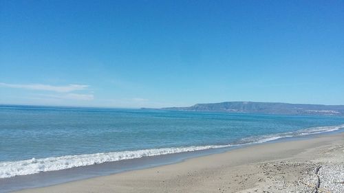 Scenic view of beach against blue sky