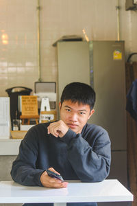 Portrait of young man sitting at classroom