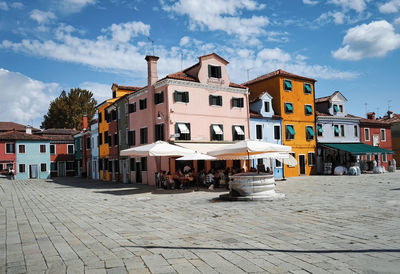 Houses by street in town against sky