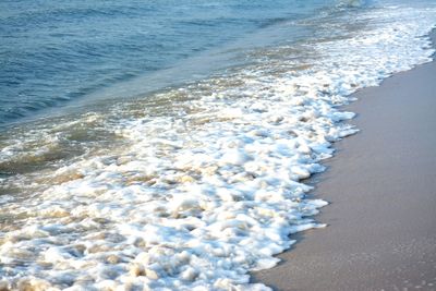 High angle view of waves rushing towards shore