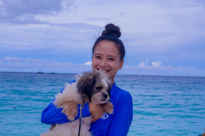 Portrait of woman with dog at beach