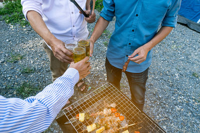 Low section of man and woman standing on barbecue grill