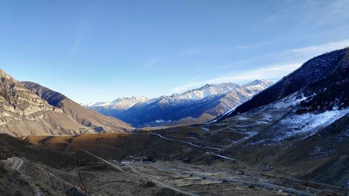 Scenic view of snowcapped mountains against blue sky