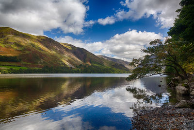 Scenic view of lake by mountains against sky