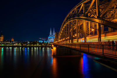 Illuminated bridge over river at night