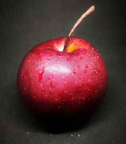 Close-up of red apple against black background