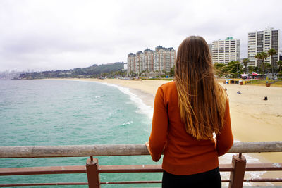 Rear view of woman enjoying view playa el sol beach in vina del mar, valparaiso, chile