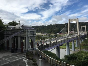 Bridge over river against cloudy sky