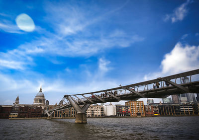 Bridge over river against buildings in city