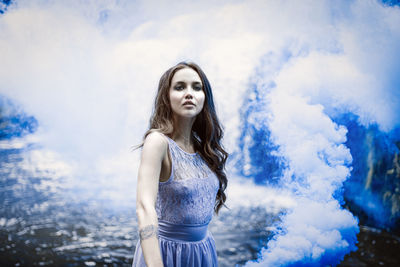 Young woman standing against sky