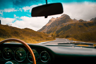 Vintage car on road seen through windshield