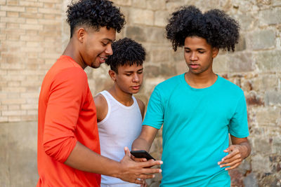 Multiethnic friends using mobile phone in the street