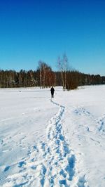 Man on snow field against clear blue sky