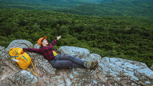 People sitting on rock against mountains