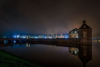 Reflection of illuminated bridge over river at night