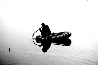 Rear view of silhouette man on boat