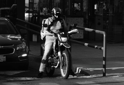 Man riding motorcycle on street in city