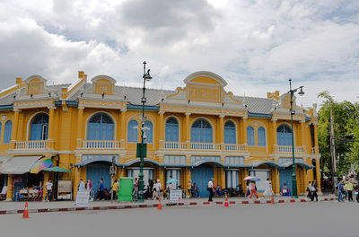 People on street against buildings in city