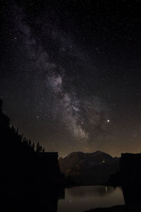 Scenic view of silhouette mountain against sky at night