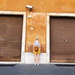 Full length rear view of man standing in building