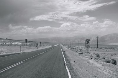 Empty road against cloudy sky