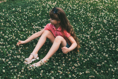 Full length of woman sitting on field