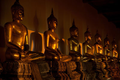 Golden buddha statues in row at temple