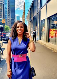 Portrait of young woman standing in city