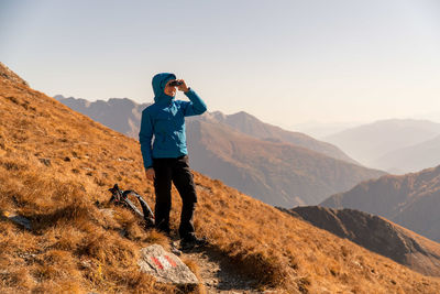 Full length of man standing on mountain against sky