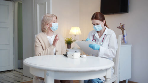 Doctor wearing mask examining patient