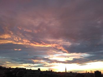 Silhouette of city against dramatic sky