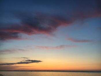 Scenic view of sea against dramatic sky during sunset