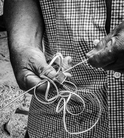 Midsection of hand cutting string