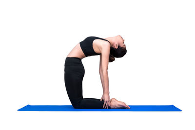 Midsection of young woman with arms raised against white background