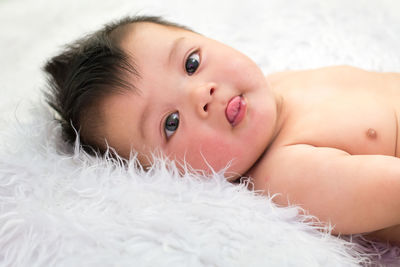 Portrait of cute baby boy lying on fur