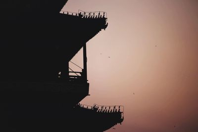 Silhouette of building against clear sky at sunset