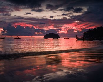 Scenic view of sea against dramatic sky during sunset