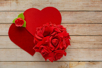 Close-up of red rose on wooden table