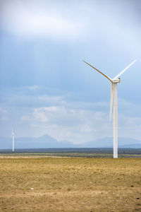 Windmill on field against sky