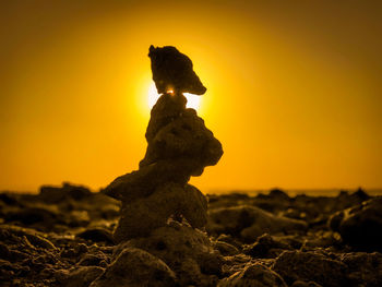 Close-up of stone stack on rock at sunset