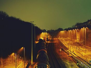 High angle view of train on railroad tracks against clear sky at night